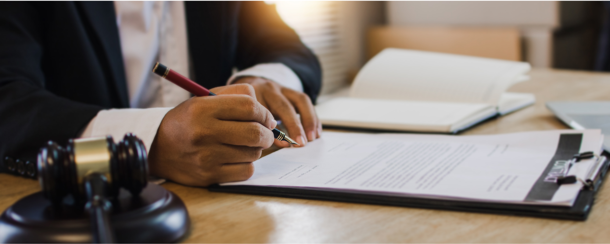 The role of a real estate attorney in a home sale, Real estate attorney signing home sale closing documents beside a legal gavel